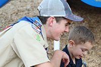  Image of Luke Fulton smiling next to Lil' Explorers student